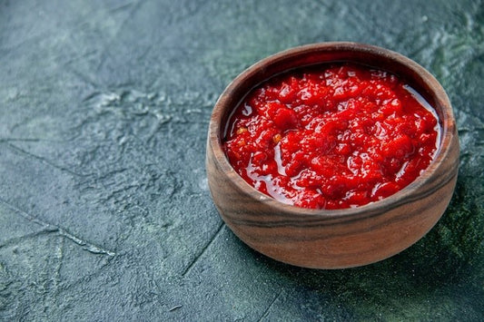 contenitore di legno con salsa chutney rosso su base di pietra